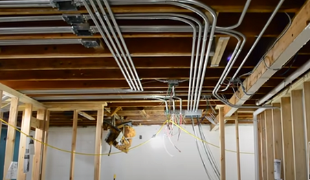 Pictures of bended conduit pipe for electrical wires in remodeled basement in Greeley Colorado.