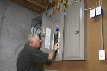 Picture of Electrician adding new circuit breaker  in main electrical panelat residential home located in Greeley CO